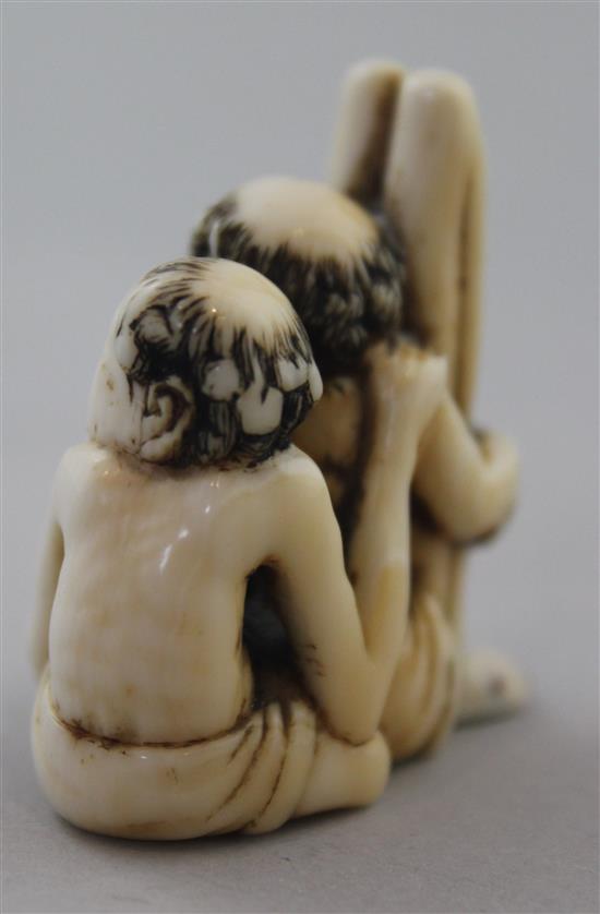 A Japanese ivory netsuke of seated Ashinaga and Tenaga, Meiji period, 3.7cm, repair to one foot